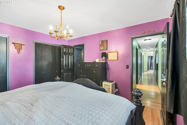 bedroom featuring an inviting chandelier and hardwood / wood-style flooring