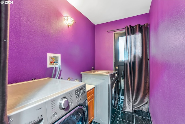 clothes washing area featuring washer and dryer and dark tile patterned flooring