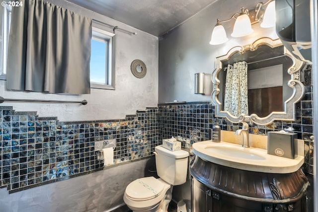 bathroom with vanity, tile walls, and toilet