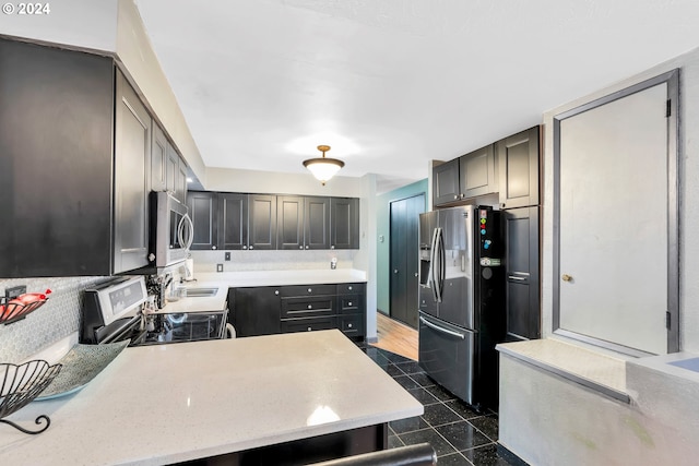 kitchen with gray cabinets, dark tile patterned flooring, sink, stainless steel appliances, and backsplash