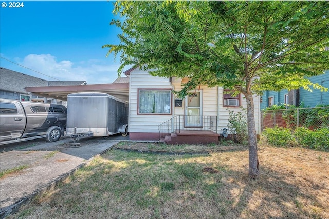 view of front of home featuring an attached carport and fence