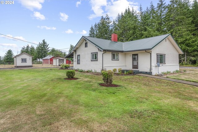 view of front facade featuring a front lawn and an outbuilding