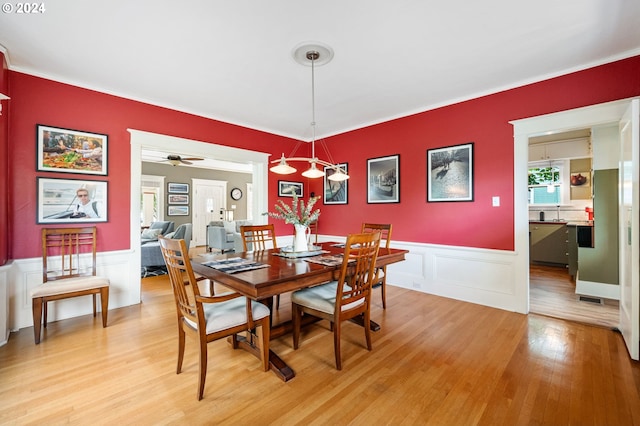 3107 N Rosa Parks Way, Portland, OR 97217 - dining space featuring light wood-type flooring, a decorative wall, a wainscoted wall, crown molding, and ceiling fan