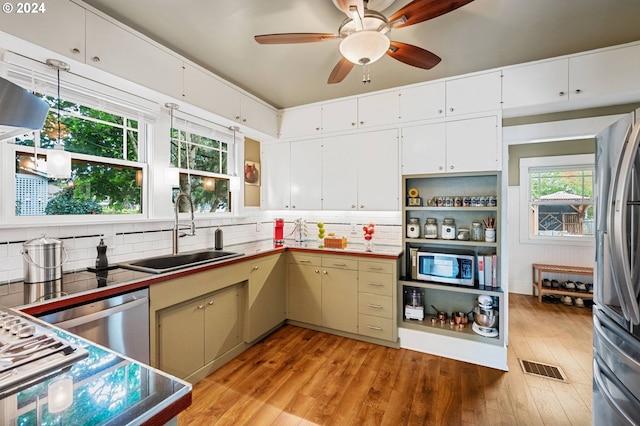 kitchen featuring sink, light hardwood / wood-style flooring, stainless steel appliances, and backsplash