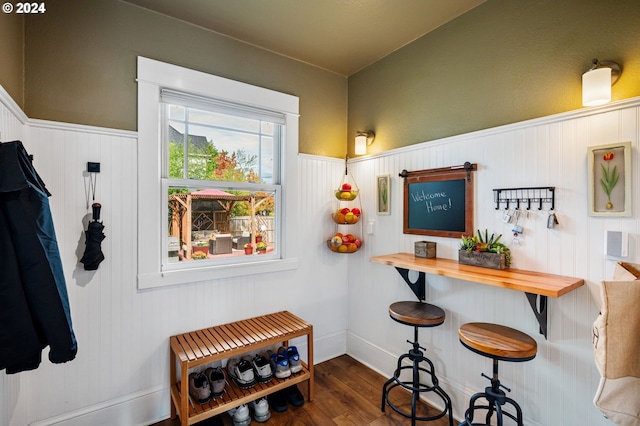 bar with a wainscoted wall and wood finished floors