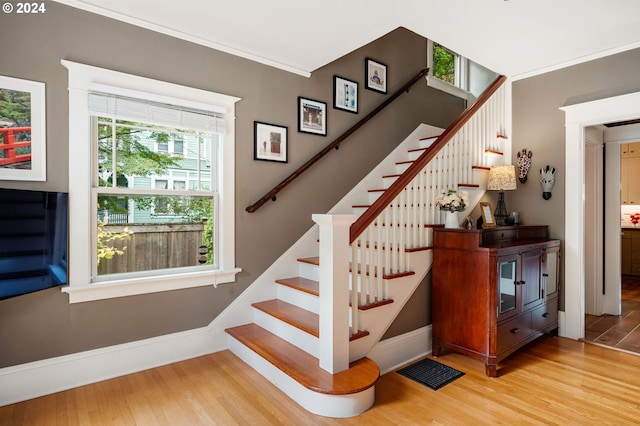 staircase featuring crown molding and hardwood / wood-style flooring