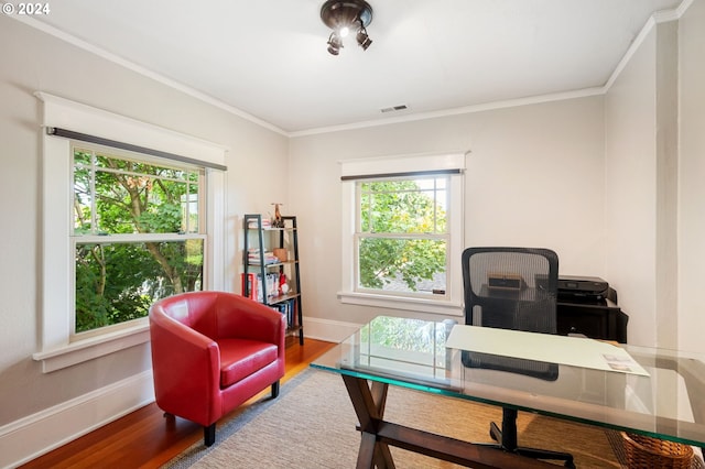 home office with crown molding, wood finished floors, baseboards, and visible vents