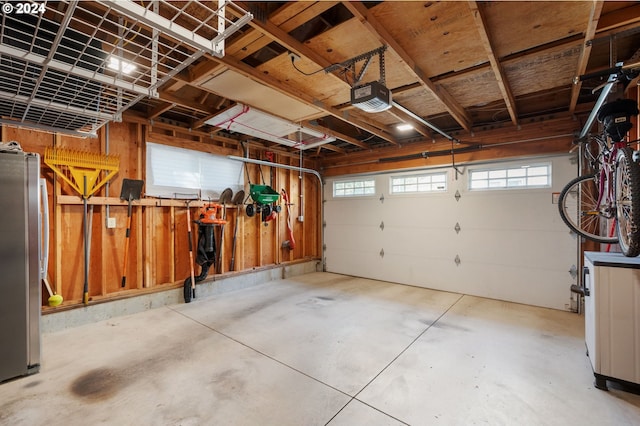 garage featuring a garage door opener and freestanding refrigerator