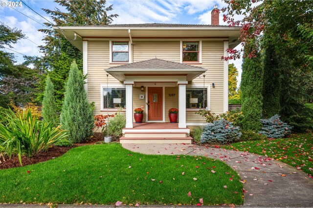 view of property featuring a porch and a front yard