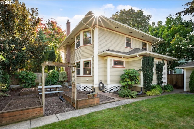 exterior space with a front lawn, a chimney, fence, and a vegetable garden