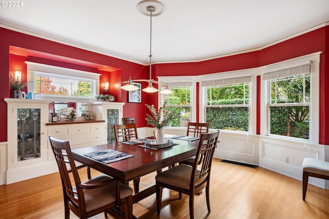 3107 N Rosa Parks Way, Portland, OR 97217 - dining space with light wood-type flooring, crown molding, a decorative wall, and a wainscoted wall