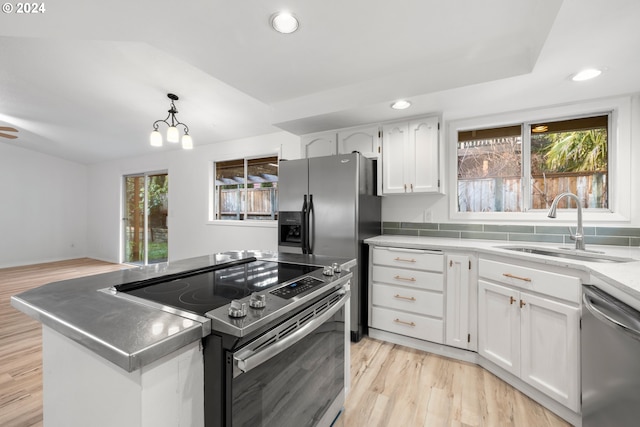 kitchen with pendant lighting, a wealth of natural light, white cabinetry, stainless steel appliances, and sink