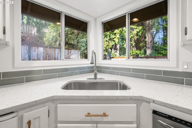 kitchen featuring decorative backsplash, sink, and white cabinetry