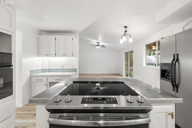 kitchen with ceiling fan with notable chandelier, pendant lighting, white cabinetry, stainless steel appliances, and light hardwood / wood-style floors