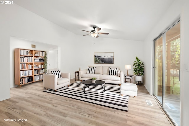 living room featuring ceiling fan, lofted ceiling, and light hardwood / wood-style floors