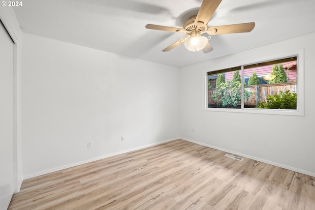 unfurnished room featuring light wood-type flooring and ceiling fan