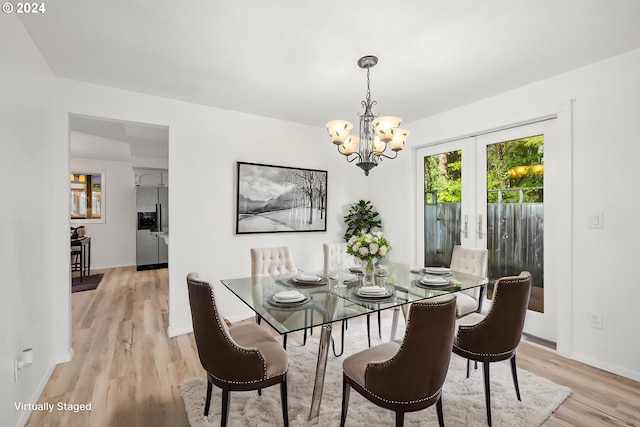 dining area featuring french doors, a notable chandelier, and light hardwood / wood-style floors