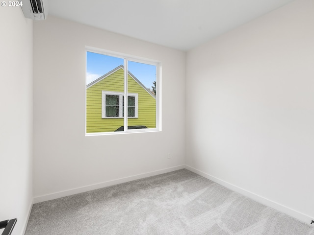 carpeted spare room featuring an AC wall unit