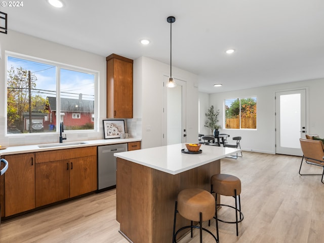 5275 N Vancouver Ave Unit 1, Portland, OR 97217 - kitchen featuring a sink, dishwasher, light wood-style flooring, light countertops, and hanging light fixtures