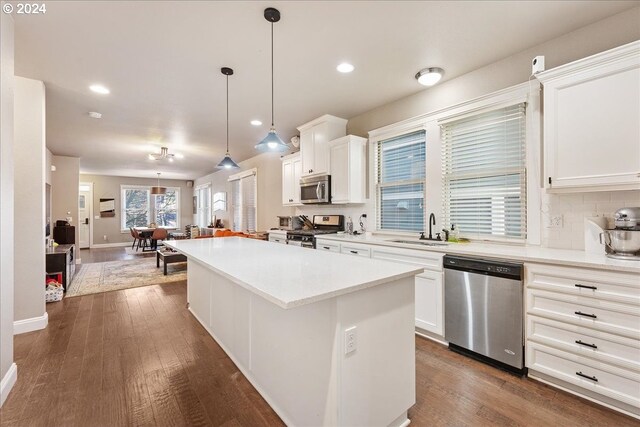 kitchen featuring white cabinetry, pendant lighting, appliances with stainless steel finishes, and a kitchen island