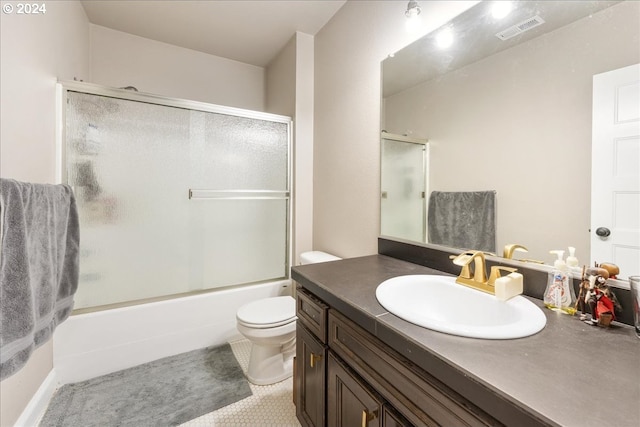 full bathroom with combined bath / shower with glass door, vanity, and toilet