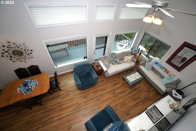 living room featuring a towering ceiling, ceiling fan, and dark hardwood / wood-style flooring