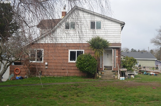 rear view of property with a lawn and a chimney