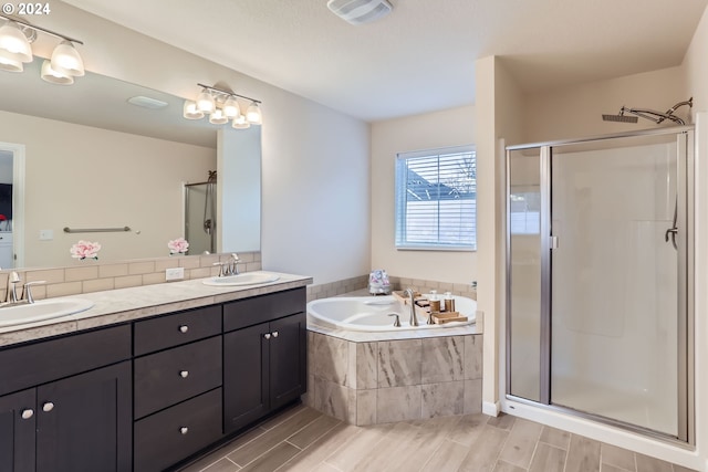 bathroom featuring vanity and separate shower and tub