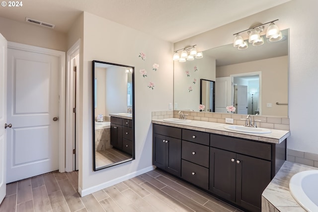 bathroom with vanity and a relaxing tiled tub