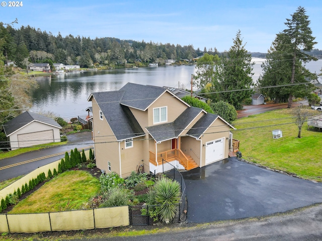 view of front facade with a garage, a front lawn, and a water view