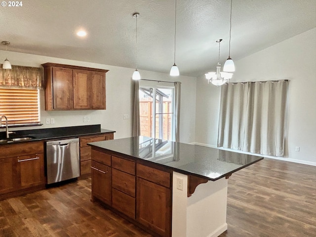 kitchen with a sink, dark countertops, stainless steel dishwasher, and decorative light fixtures