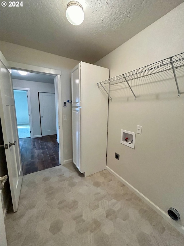 washroom featuring laundry area, light colored carpet, hookup for a washing machine, a textured ceiling, and hookup for an electric dryer