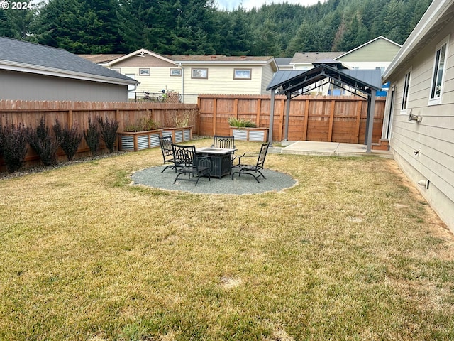 view of yard with a gazebo, a forest view, a patio area, and a fenced backyard