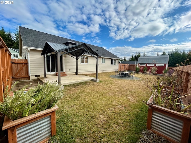 view of yard featuring a patio area, a fenced backyard, a storage shed, and an outbuilding