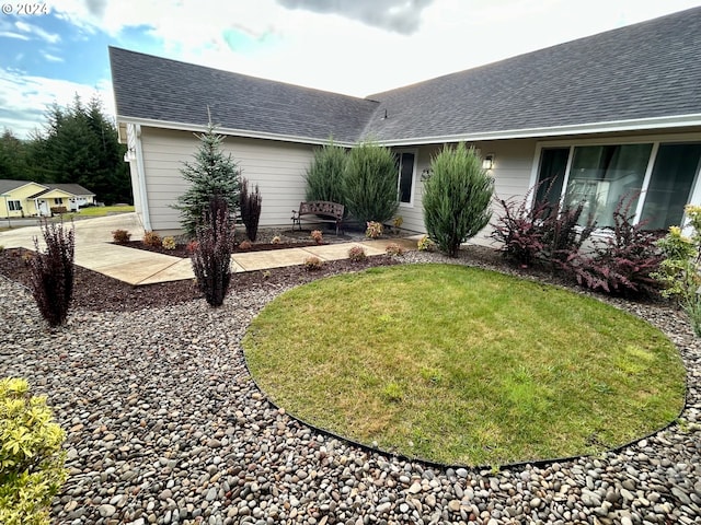 view of front of home with a shingled roof and a front lawn