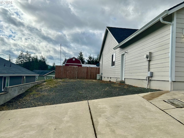 view of side of property featuring fence and a patio