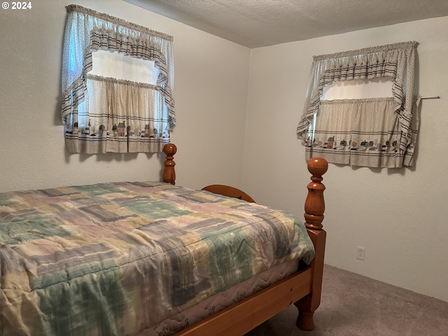 carpeted bedroom featuring a textured ceiling