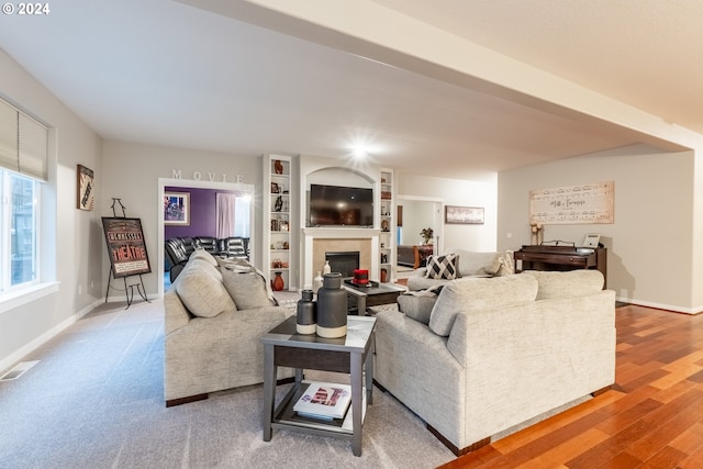 living room with built in shelves and hardwood / wood-style floors