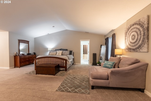 carpeted bedroom with vaulted ceiling and ensuite bath