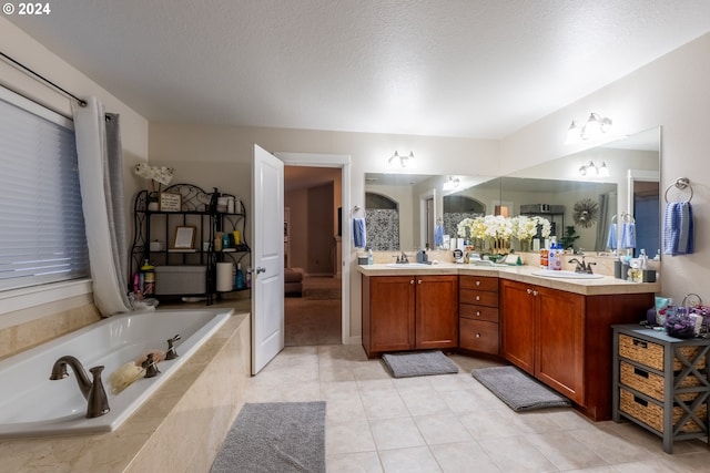 bathroom featuring tile patterned flooring, vanity, a textured ceiling, and tiled tub