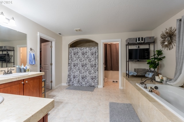 bathroom with vanity, a textured ceiling, and tile patterned floors