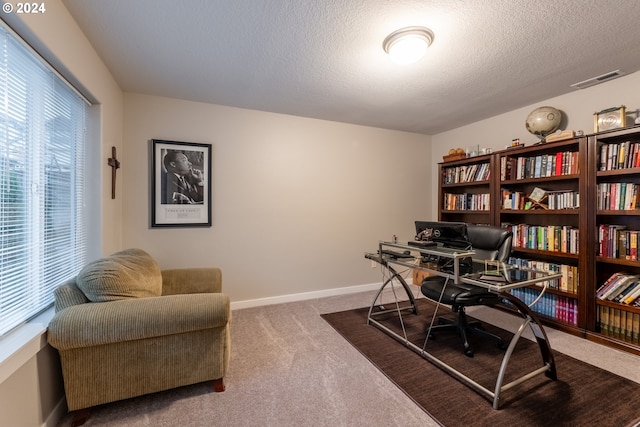 carpeted home office with a textured ceiling