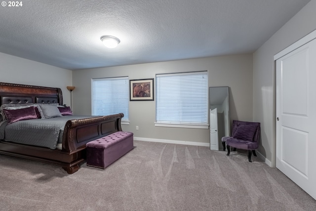 carpeted bedroom featuring a textured ceiling