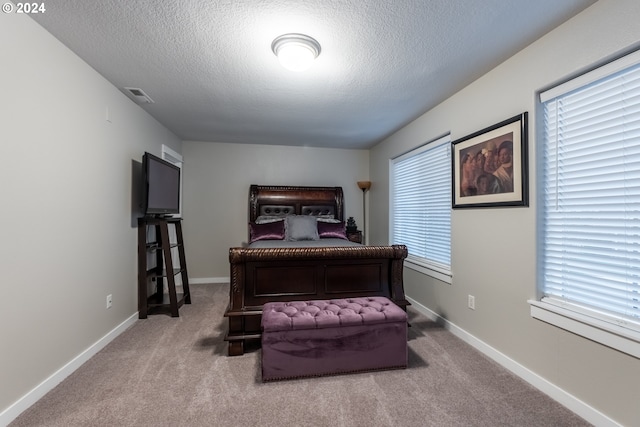 carpeted bedroom featuring a textured ceiling