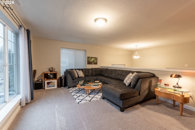 carpeted living room featuring a textured ceiling