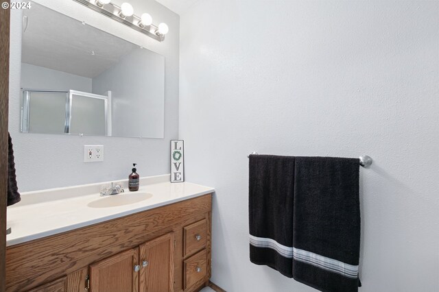 bathroom with walk in shower and vanity