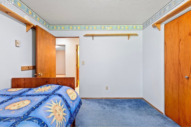 bedroom featuring a textured ceiling and carpet flooring