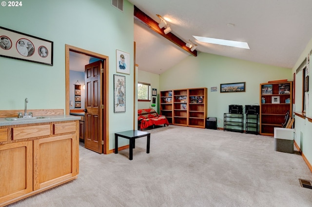 living area with light carpet, lofted ceiling with skylight, and sink