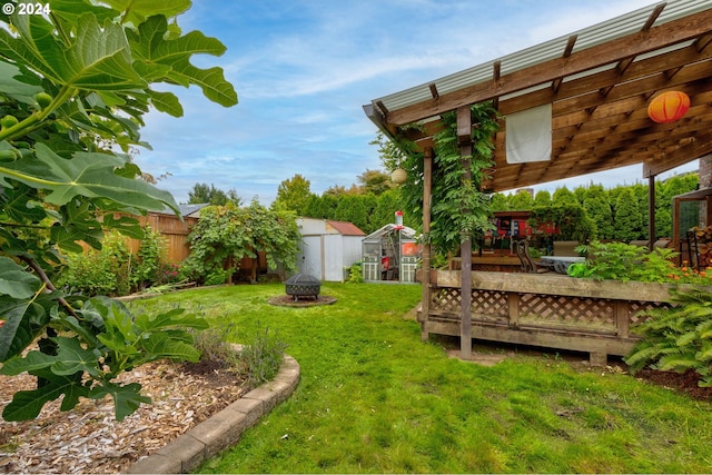 view of yard with an outdoor fire pit and a storage unit