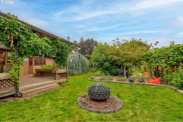 view of yard featuring a wooden deck and an outdoor fire pit